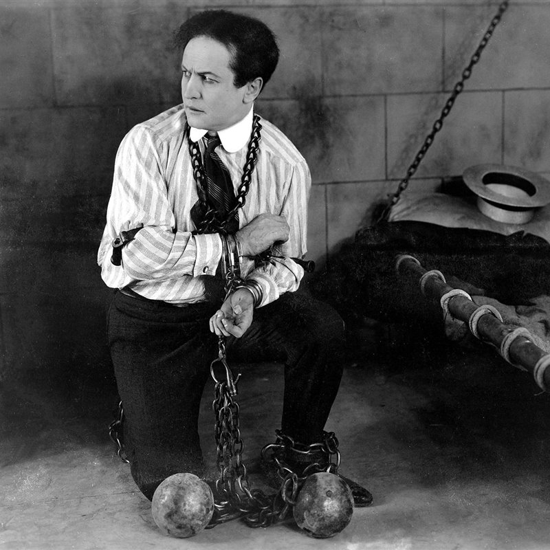 Harry Houdini trying to get free of chains