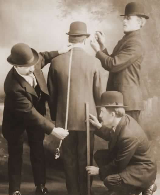 Vintage picture of tailors takeing measurement